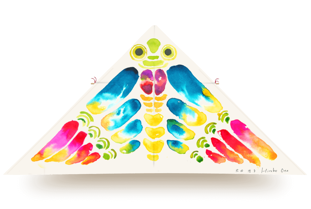 Delta kite titled Brave, featuring a rainbow-colored symmetrical design with a playful creature-like face and wing shapes, by artist Hiroko Ota